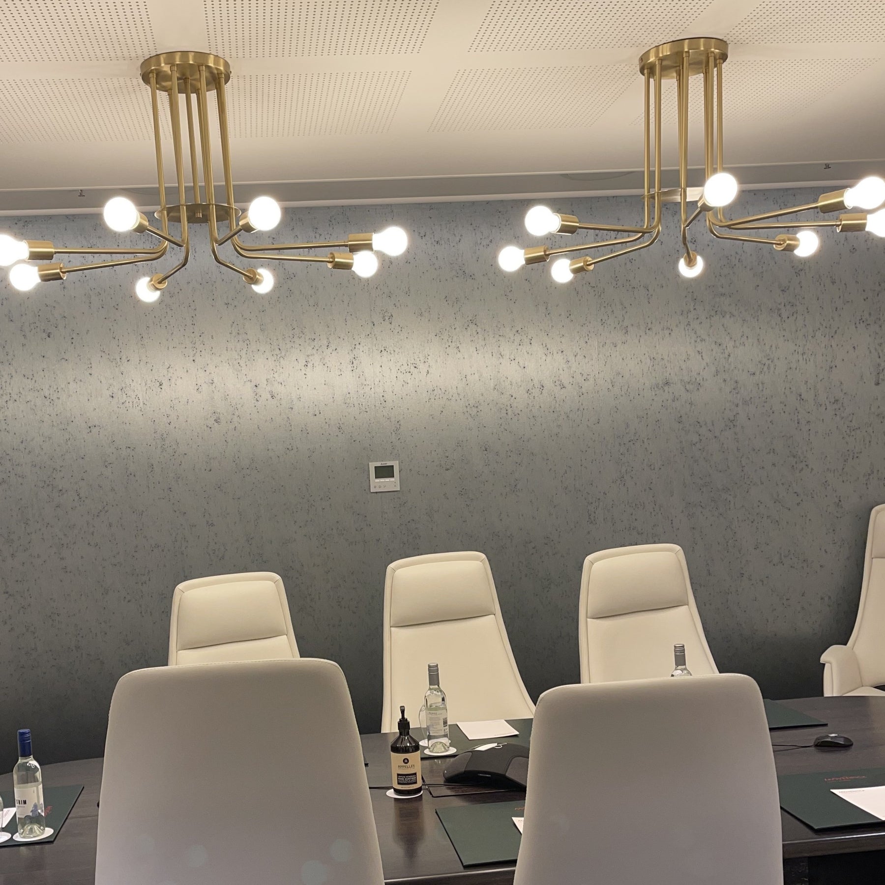 Large 900m Brass pendant lamp with 8 arms and exposed bulbs, shown in a hotel boardroom in Australia