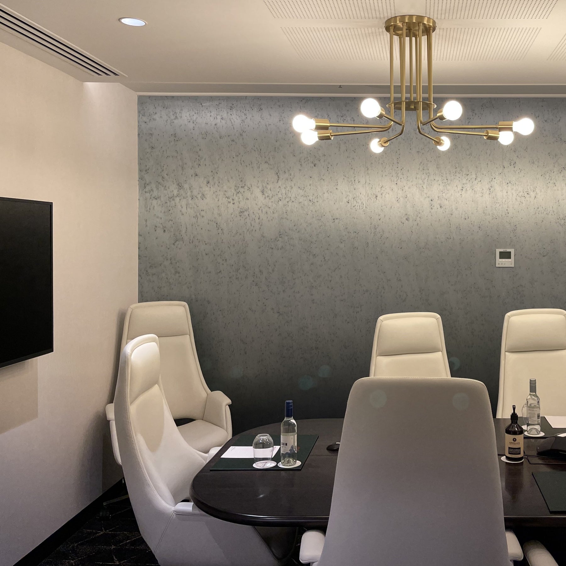 Large 900m Brass pendant lamp with 8 arms and exposed bulbs, shown in a hotel boardroom in Hobart Australia